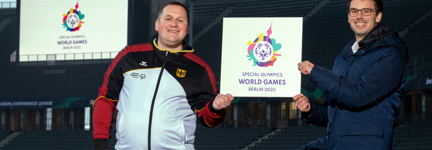 Dennis Mellentin (left), athletes spokesman Special Olympics Berlin, and Sven Albrecht, CEO LOC Special Olympics World Games Berlin 2023 and CEO Special Olympics Germany, present the logo in the Olympic Stadium in Berlin, opening ceremony venue in June 2023.